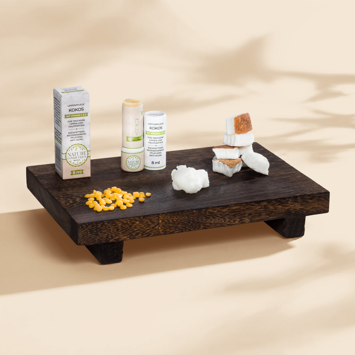 Nature Cosmétique Lippenpflege Kokos Hauptinhaltsstoffe auf Brett dargestellt